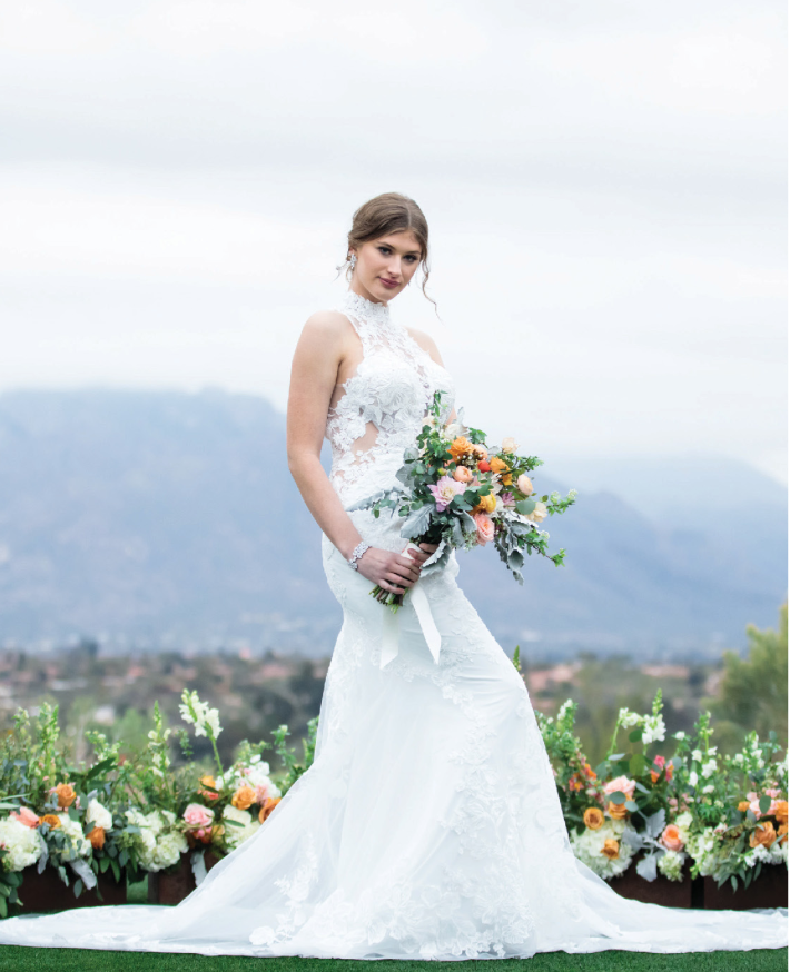 Bride holding wedding bouquet in front of the Catalina Mountain range in Tucson Arizona at Omni Tucson National Resort